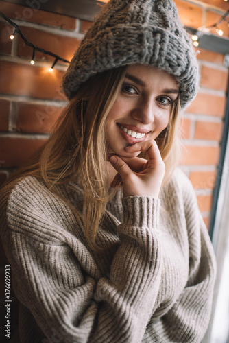 Young smiling blonde in sweater and cap