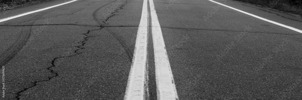 Asphalt background with two white road lines. Road markings on asphalt Asphalt background with two white road lines. Road markings on asphalt