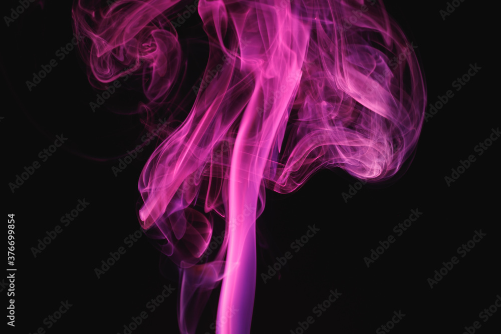Purple smoke on a black background. Colored smoke. Incense stick smoke illuminated by purple light. Purple smoke on a black background. Colored smoke. Incense stick smoke illuminated by purple light.