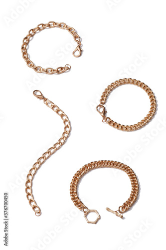 Subject shot of four golden bracelets consists of several assorted chains with lobster clasps and toggle fastener. The stylish jewelry set is isolated on the white background. 