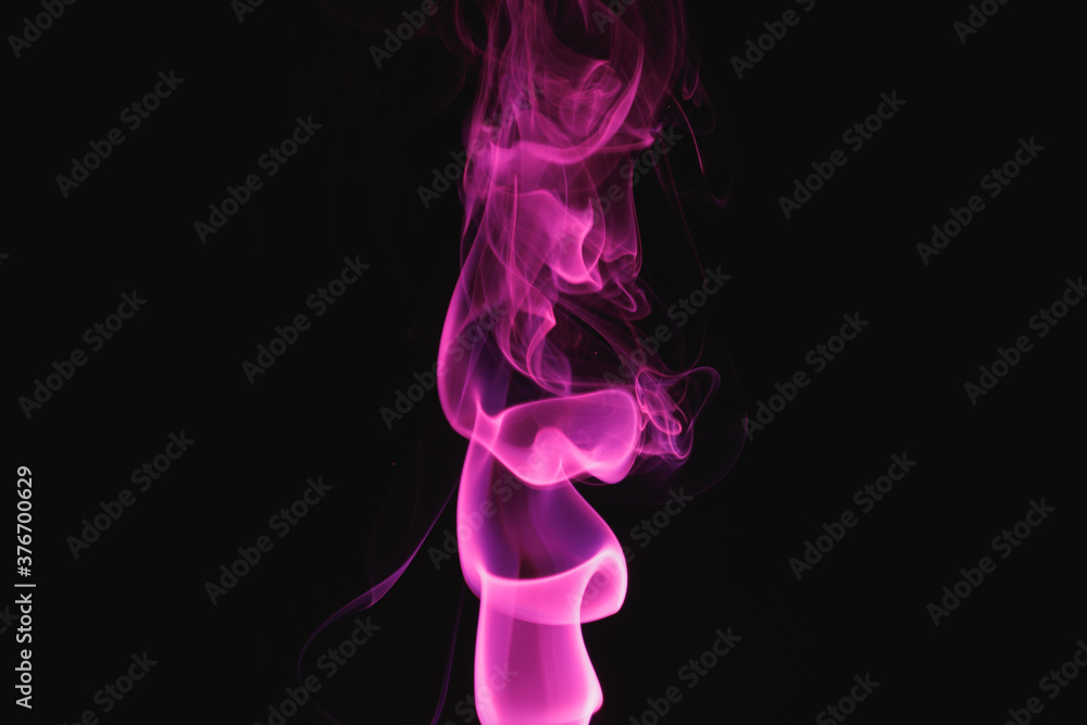 Purple smoke on a black background. Colored smoke. Incense stick smoke illuminated by purple light. Purple smoke on a black background. Colored smoke. Incense stick smoke illuminated by purple light.