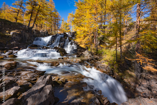 Fototapeta Naklejka Na Ścianę i Meble -  Fontcouverte Waterfall in Autumn with larch trees in the Claree Upper Valley. Nevache, Hautes-Alpes (05), Alps, France