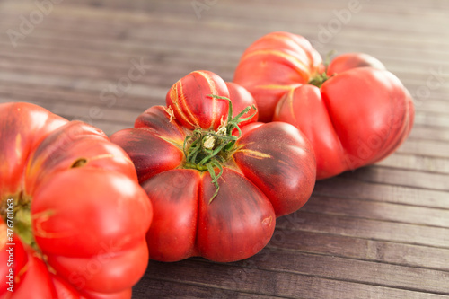 ripe appetizing merinda tomatoes on a wooden table photo