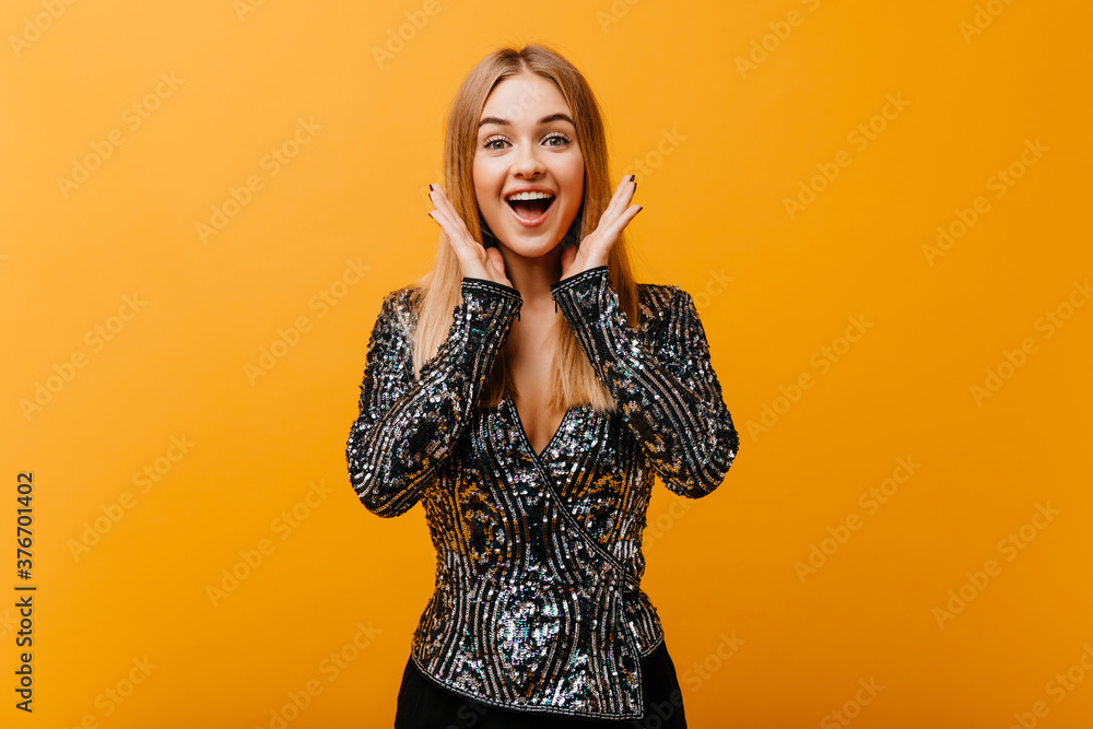 Appealing lady in party jacket smiling on orange background. Debonair female model expressing happiness. Appealing lady in party jacket smiling on orange background. Debonair female model expressing happiness.