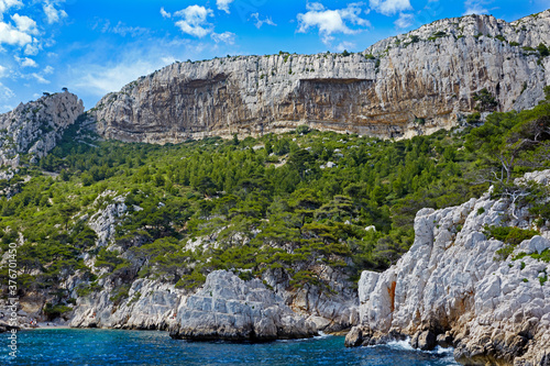 Sea view of the rugged shoreline of 'Massif des Calanques' near Marseille under blue skies