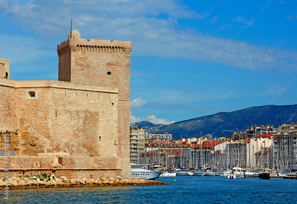 Historic tower of the 'Fort of St Jean' on the harbour entrance to Marseille under blue skies
