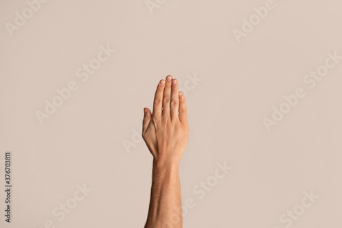 Photography Unrecognizable guy showing stop gesture over light background, closeup of hand