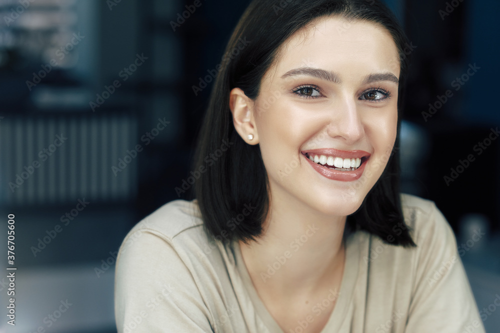 Closeup portrait of gorgeous young woman smiling with natural makeup and healthy skin looking to the camera. Pretty girl has joyful expression. Skincare concept.