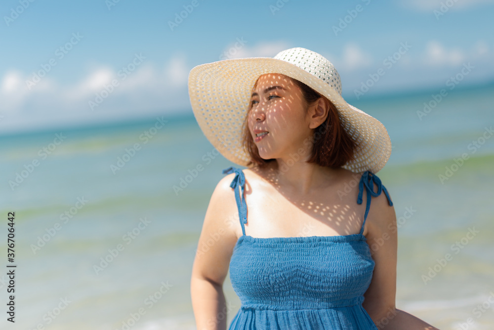  asian woman in blue dress in summer on the sand on the beach of tropical island.