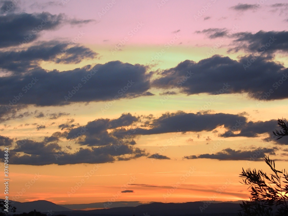 Fototapeta premium atardecer con las montañas de fondo, con las nubes en el cielo 