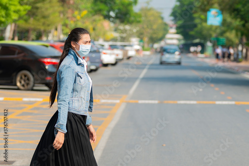 Asian woman wearing protective mask against covid19 transmissible infectious diseases and as protection against pollution. © shine