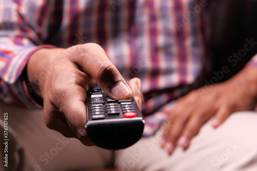 close up of man hand holding tv remote.