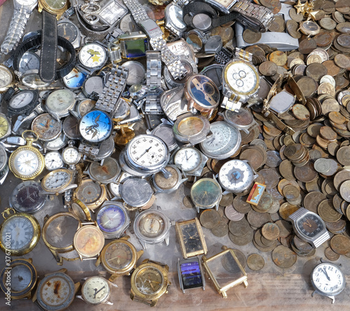 old watches, coins and metal parts at a flea market