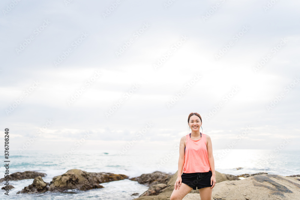 Running asian woman at the beach in the morning.Female runner jogging during outdoor workout on beach. Beautiful fit asian fitness model outdoors.Healthy lifestyle, Portrait people fitness aerobic.