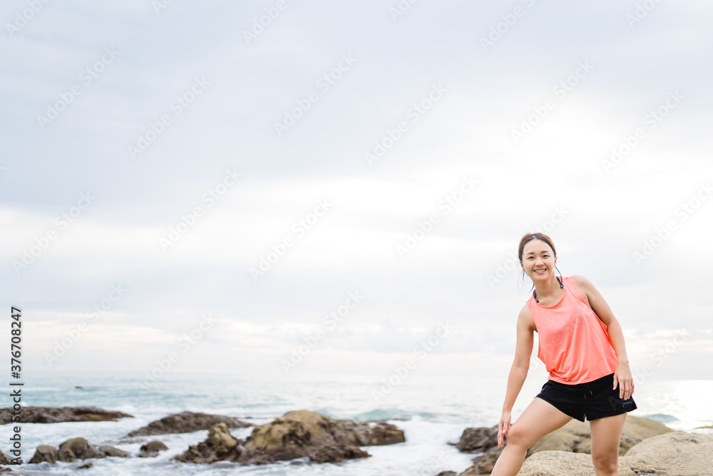 Running asian woman at the beach in the morning.Female runner jogging during outdoor workout on beach. Beautiful fit asian fitness model outdoors.Healthy lifestyle, Portrait people fitness aerobic.