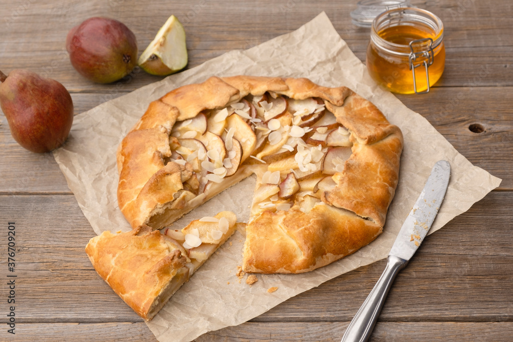 Pear pie with honey and nuts cut into pieces on an old wooden table. Homemade autumn baked goods. Pear pie with honey and nuts cut into pieces on an old wooden table. Homemade autumn baked goods.