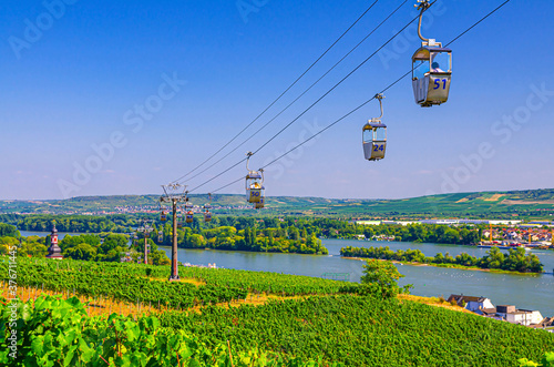 Cable car on rope of cableway from Rudesheim am Rhein town to Roseneck mount above vineyards fields of river Rhine Valley hills, blue clear sky background in sunny summer day, State of Hesse, Germany photo