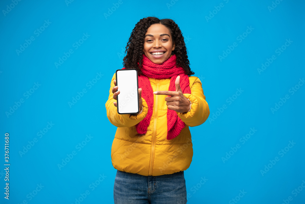 Black Woman Showing Cellphone Blank Screen Over Blue Studio Background Black Woman Showing Cellphone Blank Screen Over Blue Studio Background