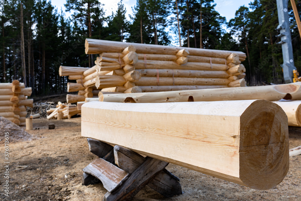 Build a house from logs. Preparation of logs for the assembly of the structure. Assembly of a wooden log house at a construction base. Build a house from logs. Preparation of logs for the assembly of the structure. Assembly of a wooden log house at a construction base.
