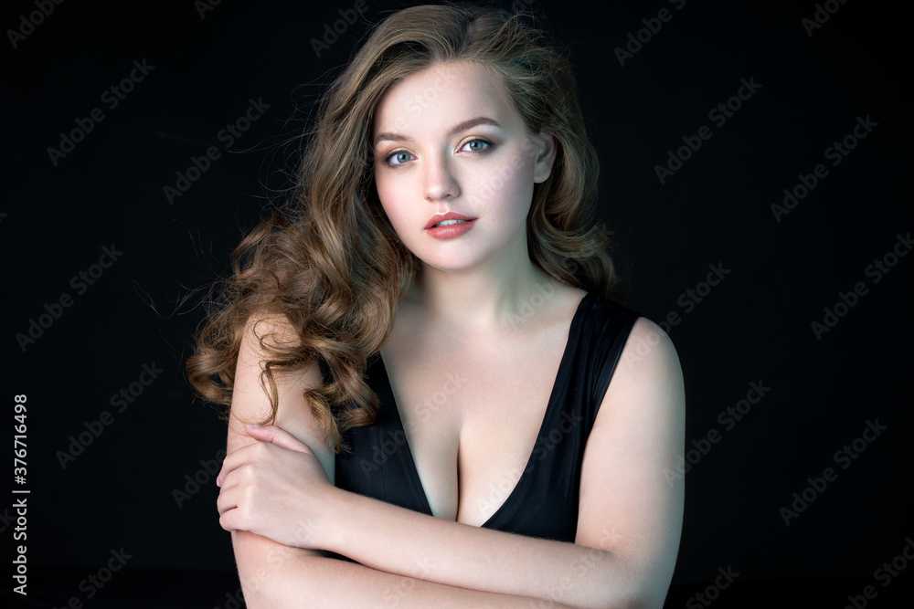 Naklejka premium Young beautiful woman with natural makeup on black background. Beauty & Skin care concept. Plus size model.