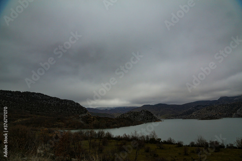 Lago en montañas rocosas con cielo nublado