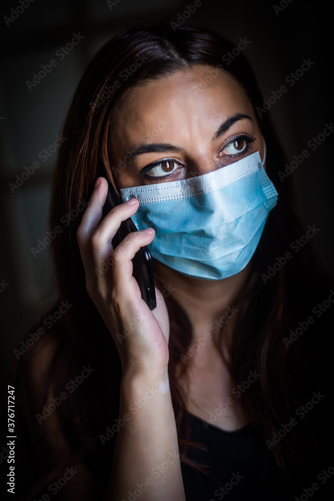 Woman talking on the mobile phone while wearing a mask Woman talking on the mobile phone while wearing a mask