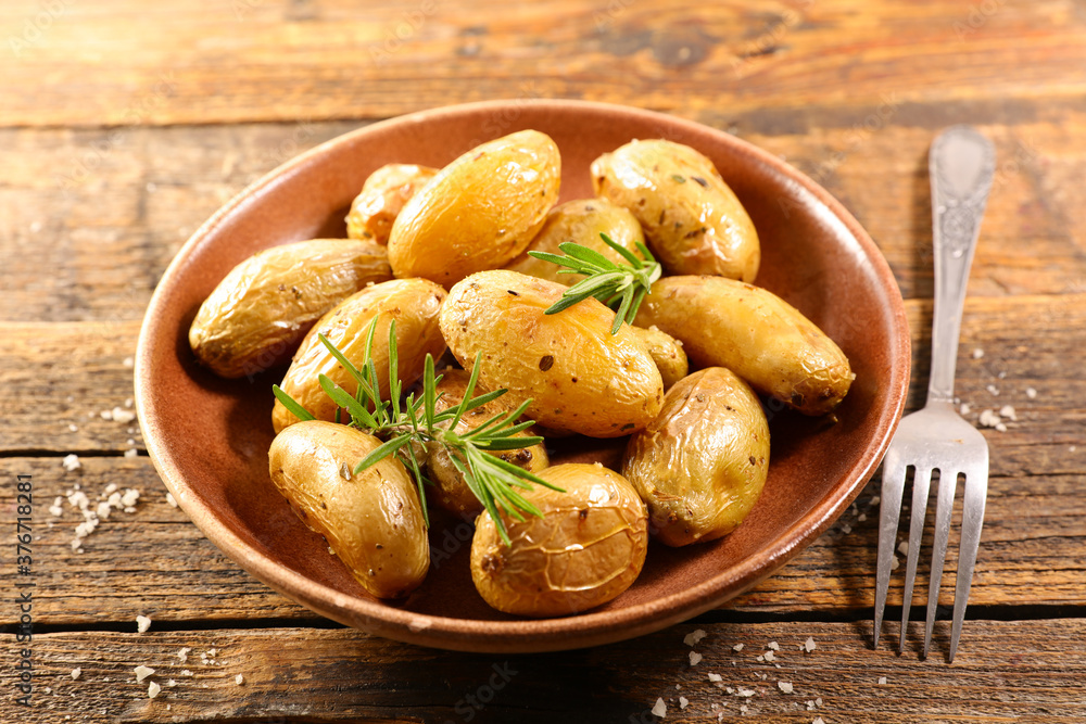 roasted potato and rosemary on wood background