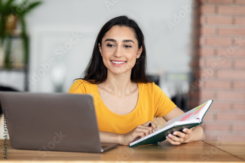 Pretty arab woman looking for job while resting at cafe © Prostock-studio