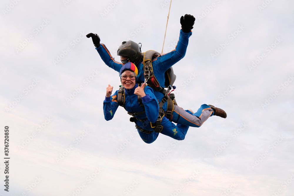 Skydiving. Tandem jump. A girl and her instructor are flying in the sky. Skydiving. Tandem jump. A girl and her instructor are flying in the sky.