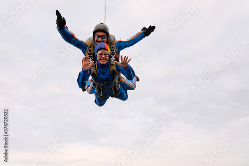 Skydiving. Tandem jump. A girl and her instructor are flying in the sky.