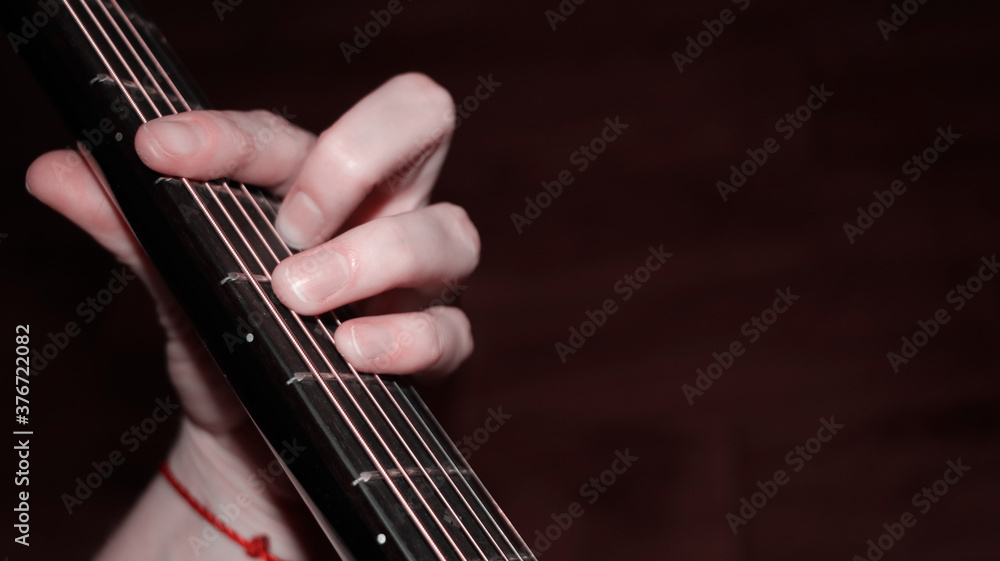 Hand putting a chord on the guitar fretboard Hand putting a chord on the guitar fretboard
