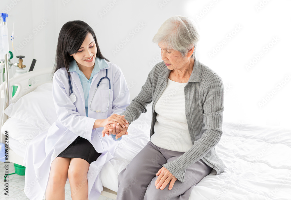 Obraz premium asian female doctor holding hand of old patient in mental health clinic, patient have a problem health in hospital, hand in hand, elderly healthcare promotion