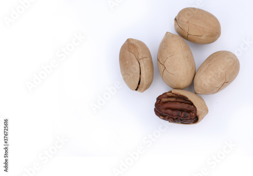 Pecan Nuts on white background, top view with copyspace. Close up veiw of nuts.