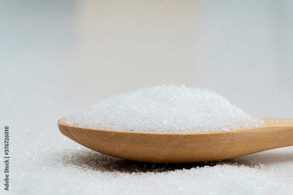 Close up scoop with white sand and lump sugar on wooden background Close up scoop with white sand and lump sugar on wooden background