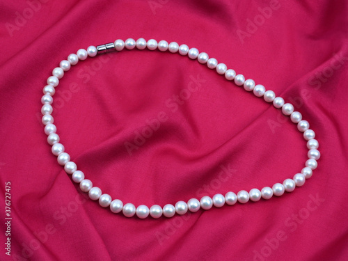 Pearl necklace on silk texture satin material