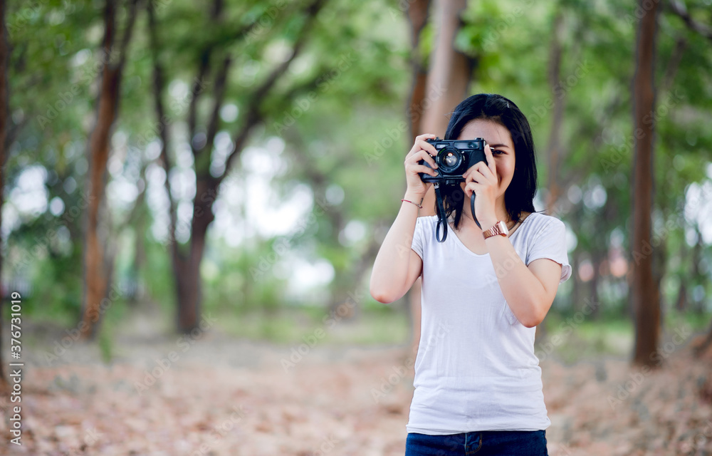 The young female photographer is happy with photography And his little camera In the natural corner The young female photographer is happy with photography And his little camera In the natural corner