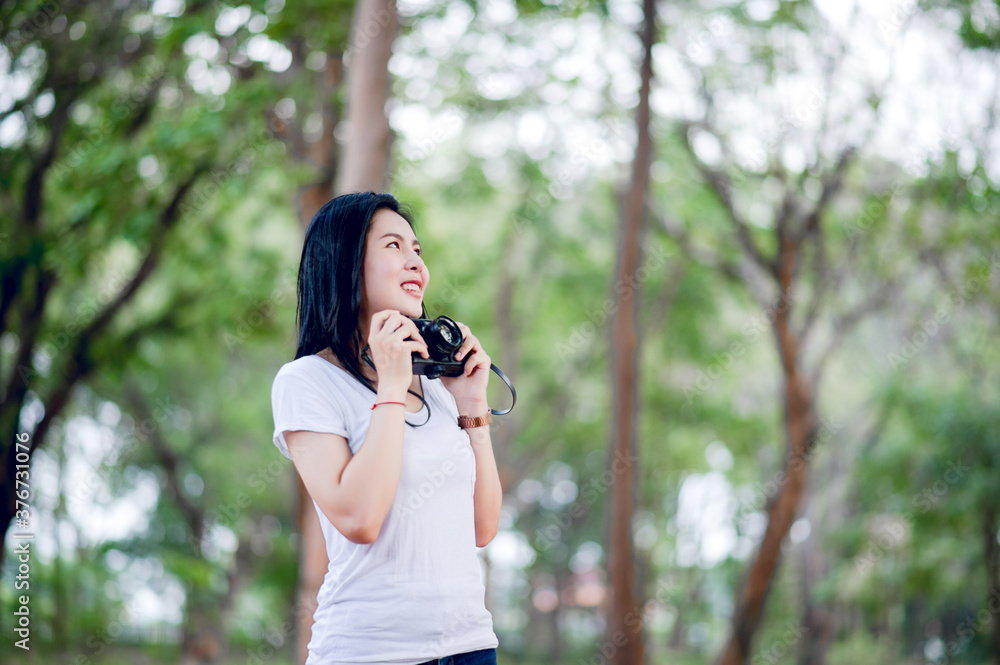 The young female photographer is happy with photography And his little camera In the natural corner The young female photographer is happy with photography And his little camera In the natural corner