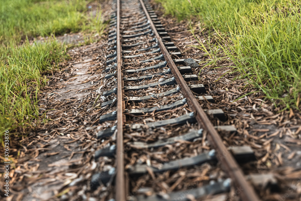 Obraz premium Old miniature train tracks at sunset.
