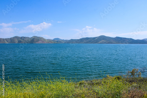 gorgeous shot of the deep blue water and lush green mountains ranges at Diamond Valley Lake in Hemet California photo