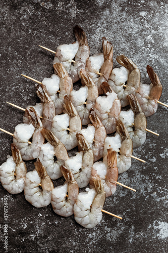 Fresh shrimps on skewers. Vertical photo.