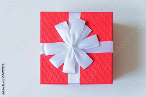 Christmas New Year birthday valentine celebration present romantic concept. Simply minimal design red gift box isolated on white background. Flat lay top view copy space. photo