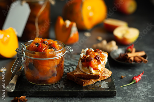 Vászonkép Homemade pumpkin and apple chutney with raisins in jars and on toast bread
