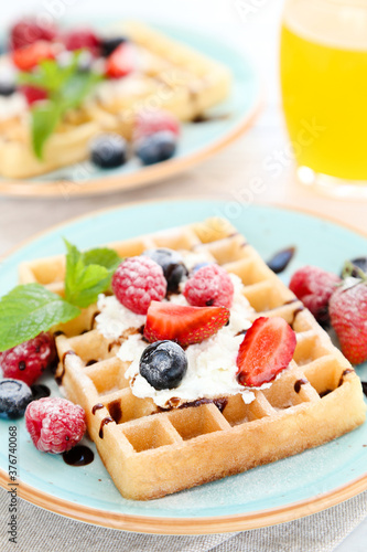 Tasty waffles with fresh berries and whipped cream