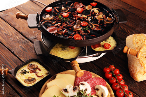 Bilde på lerret Delicious traditional Swiss melted raclette cheese served in individual skillets