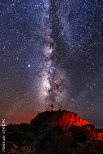 Silhouette of a young man under the stars looking at the lactea way of the Caldera de Taburiente near the Roque de los Muchahos on the island of La Palma, Canary Islands. Spain, astrophotography photo