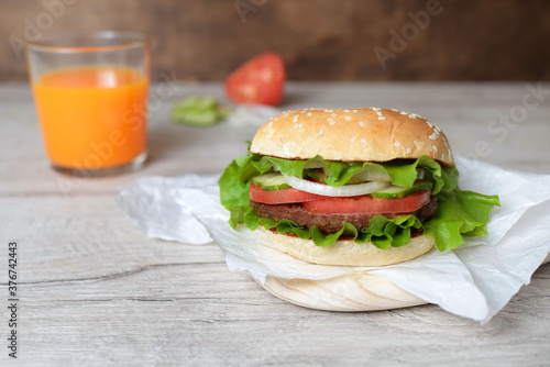 burger on a wooden background with carrot juice