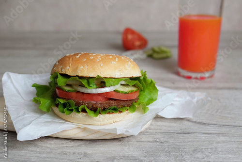 burger on a wooden background with tomatto juice