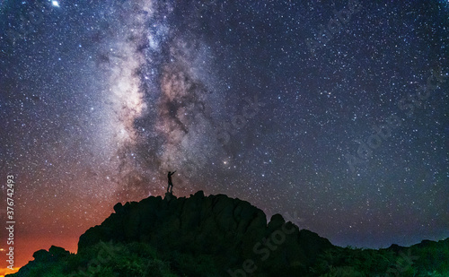 Silhouette of a young man under the stars looking at the milky way of the Caldera de Taburiente near the Roque de los Muchahos on the island of La Palma, Canary Islands. Spain, astrophotography