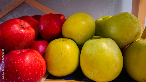 A Few Red And Green Apples Stand On A Wooden Shelf