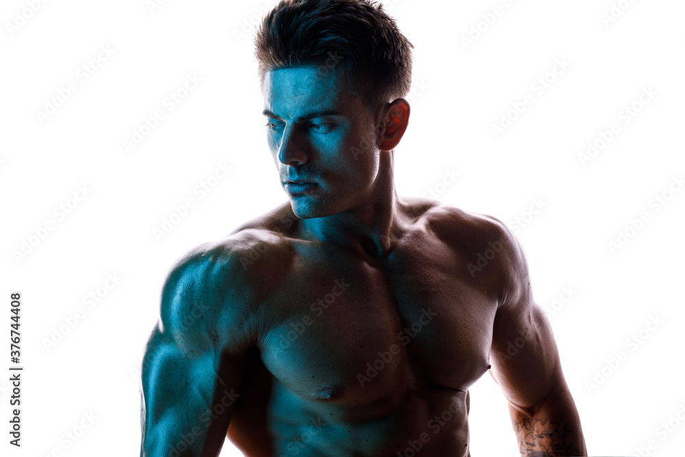 Muscular model sports young man on white background. Fashion portrait of strong brutal guy. Male flexing his muscles. Muscular model sports young man on white background. Fashion portrait of strong brutal guy. Male flexing his muscles.